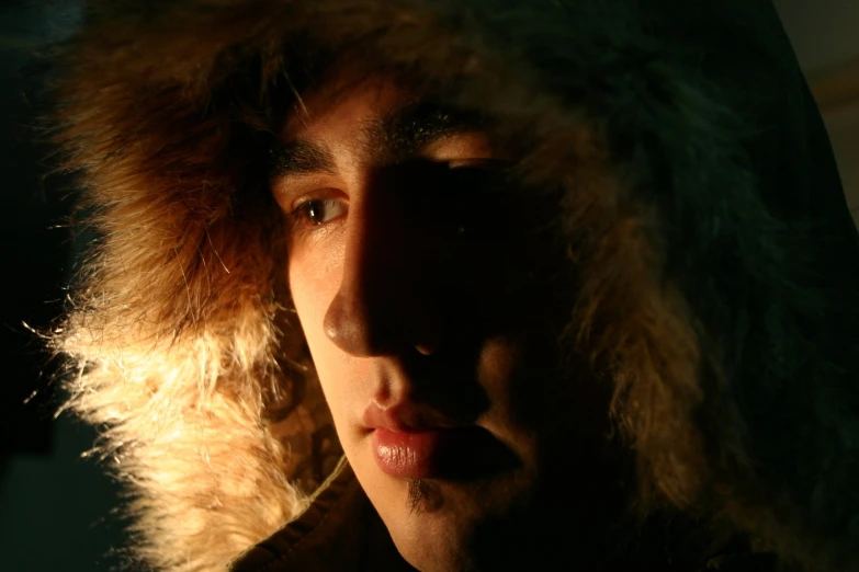 a person wearing a hooded jacket in the darkness