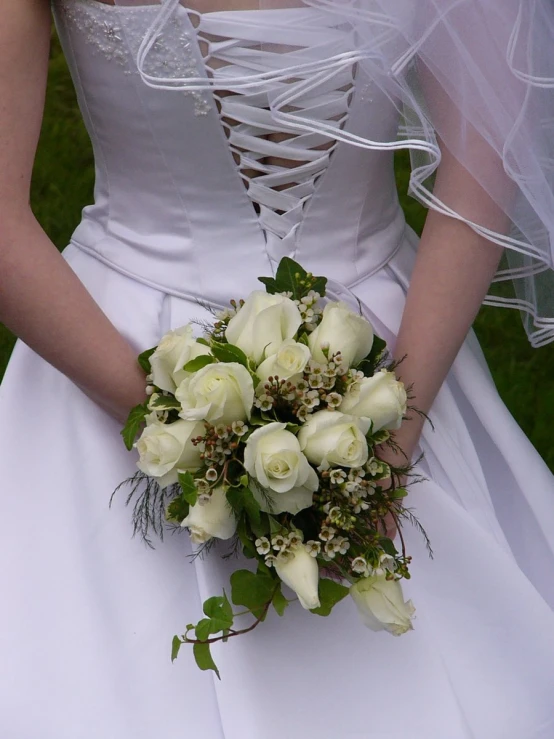 a bride holds her wedding bouquet while standing