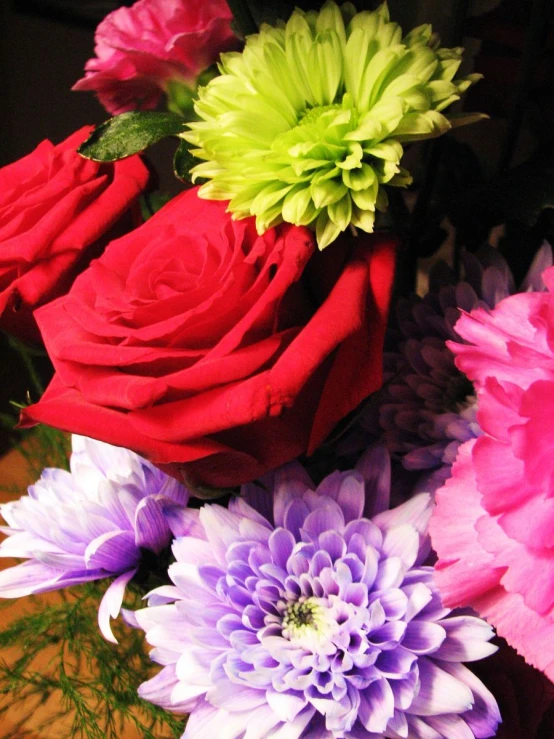 a vase full of pink, purple, and green flowers