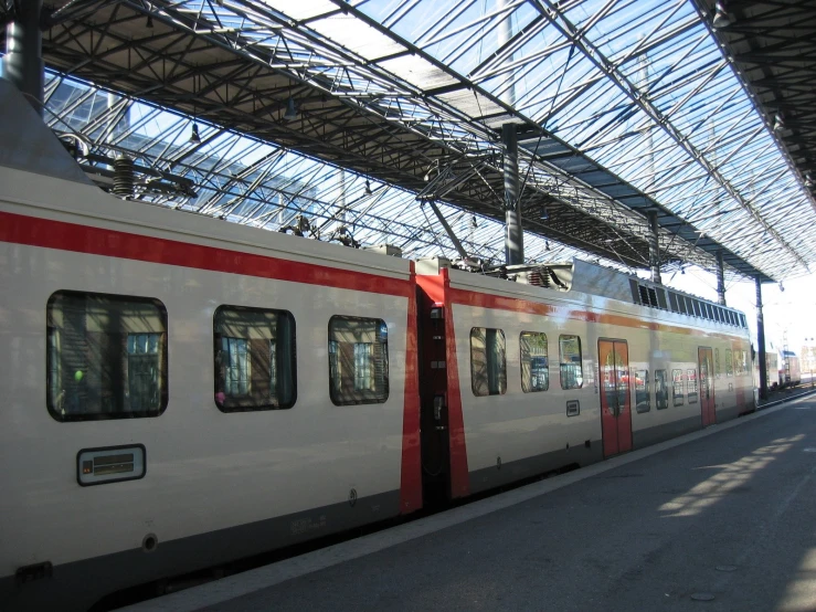 a train sits on the tracks as passengers board it