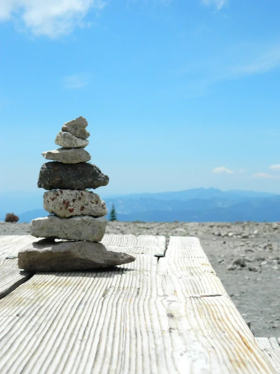 a rock balanced onto each other and resting on a wooden platform