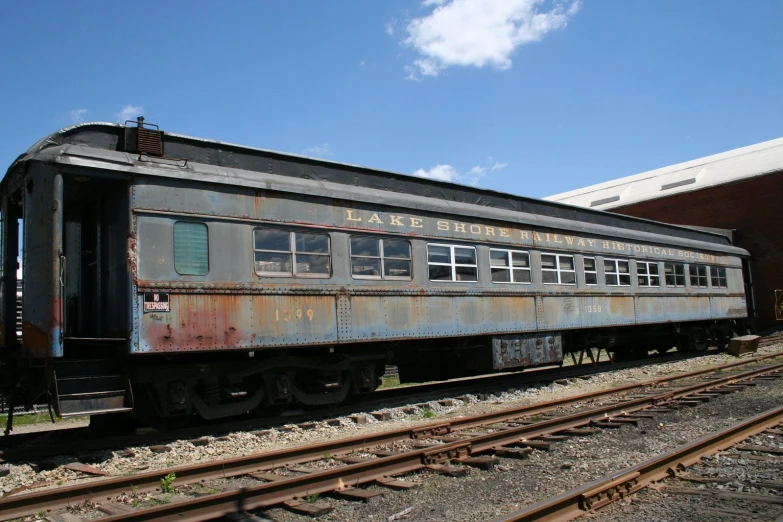 a rusty train sitting on train tracks near buildings