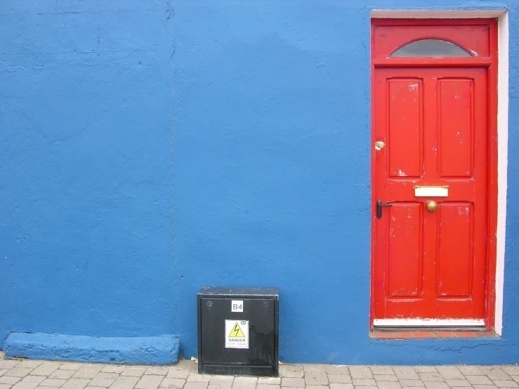 a blue and red wall with a red door