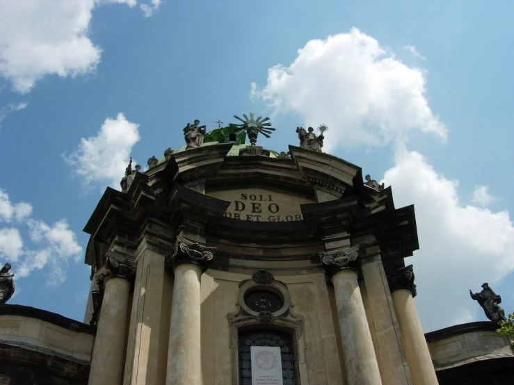 the front view of a large building with clocks and statues on top