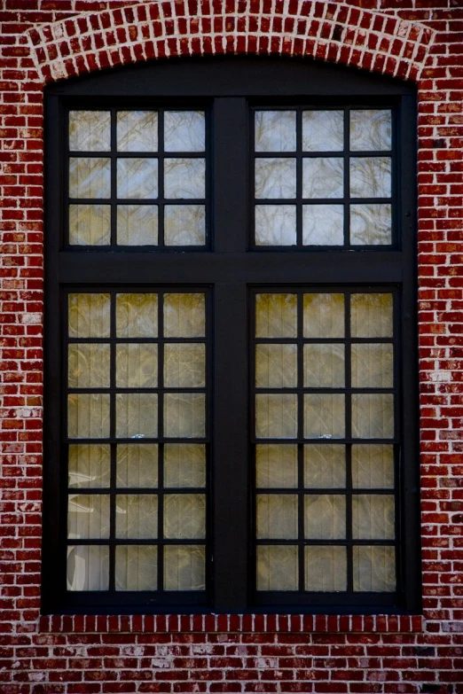 the reflection of a brick building with a window in it