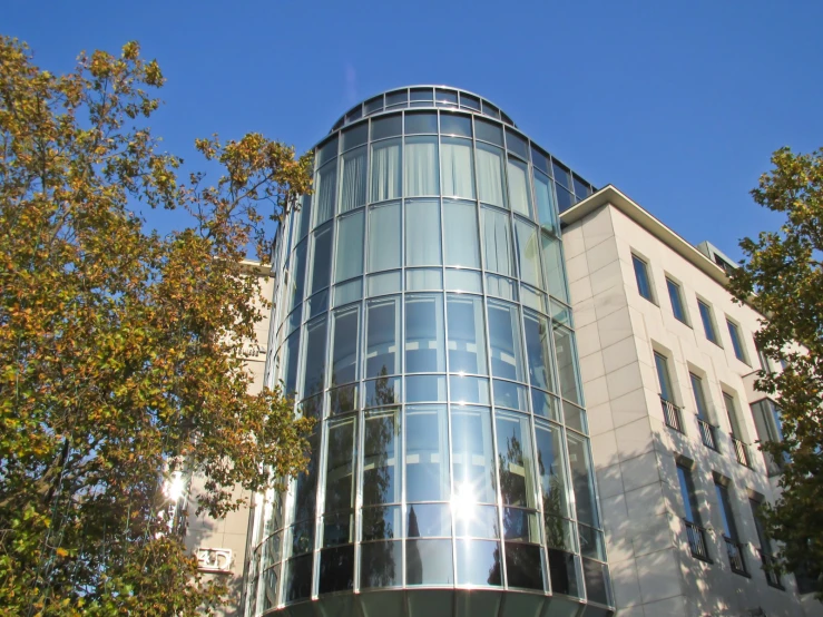 an architectural building surrounded by trees on a sunny day