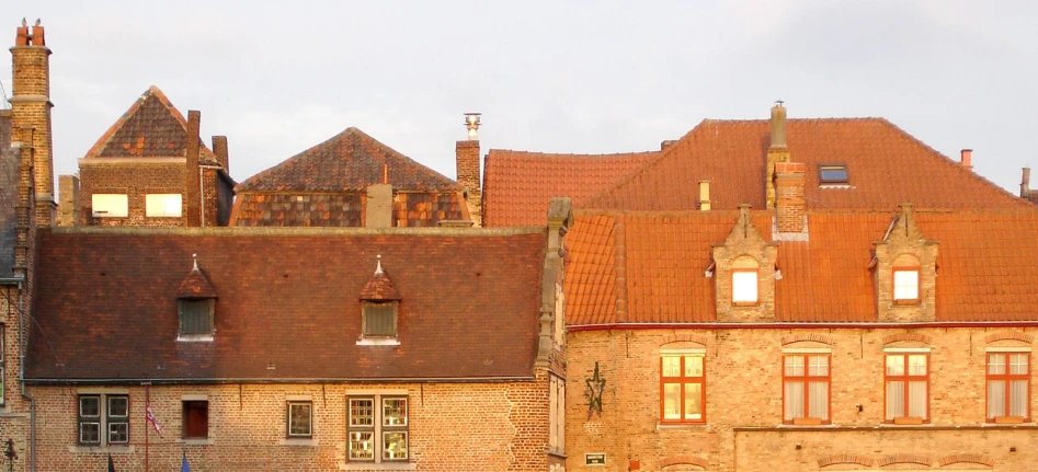 view of a large brick building with red roof and windows