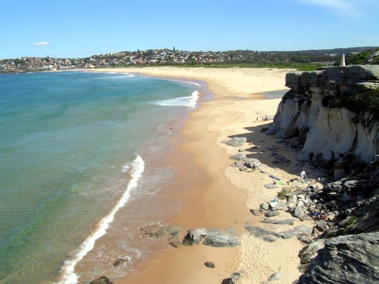 a scenic view of a beach, sea, and town