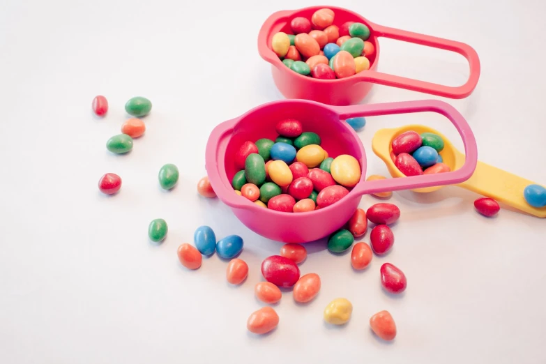 three bowls of candy on a white surface