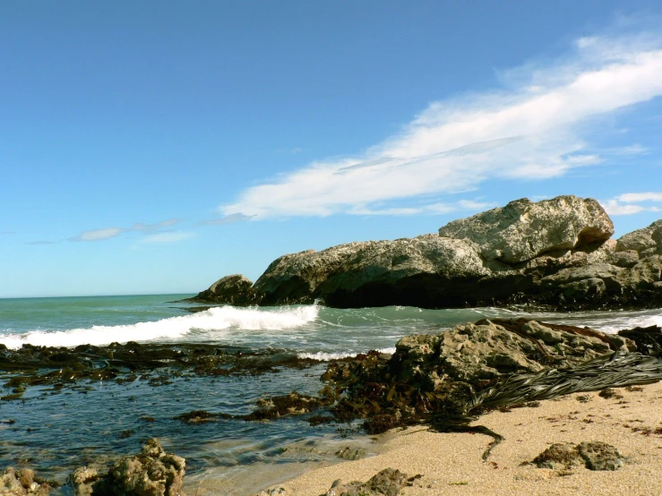 a beach with an ocean and a rock formation