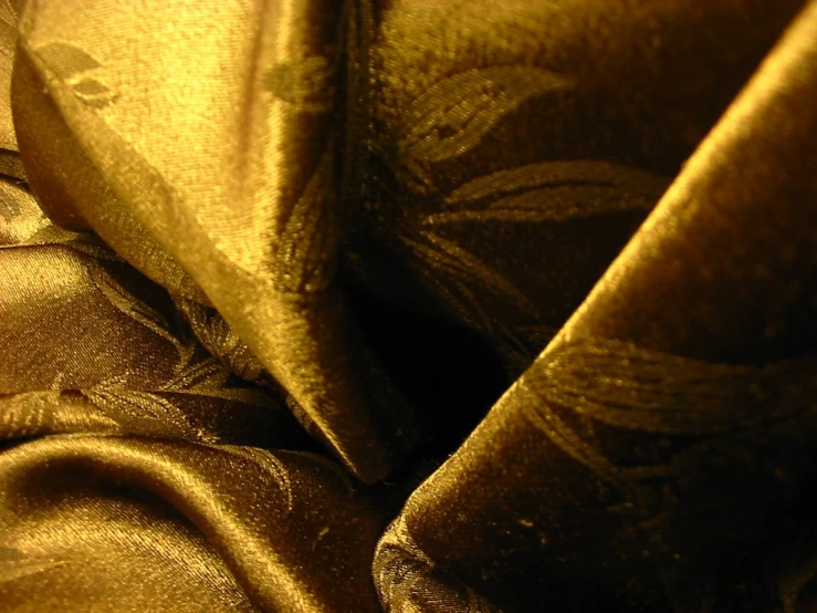 a shiny golden cloth that has flowers and leaves on it