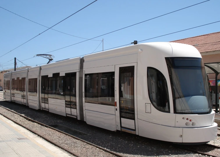 the long train is on a track near many power lines