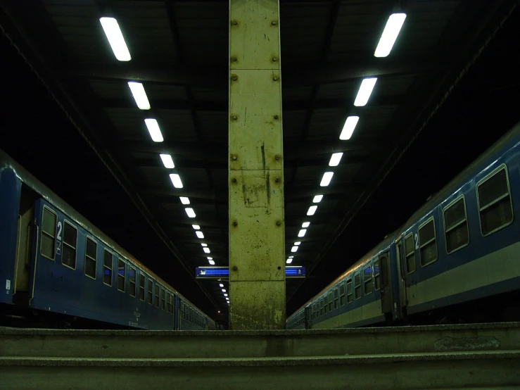 two trains passing by on train tracks in an underground area