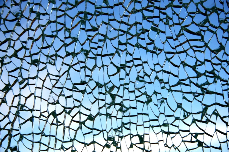 broken glass against a blue sky and clouds