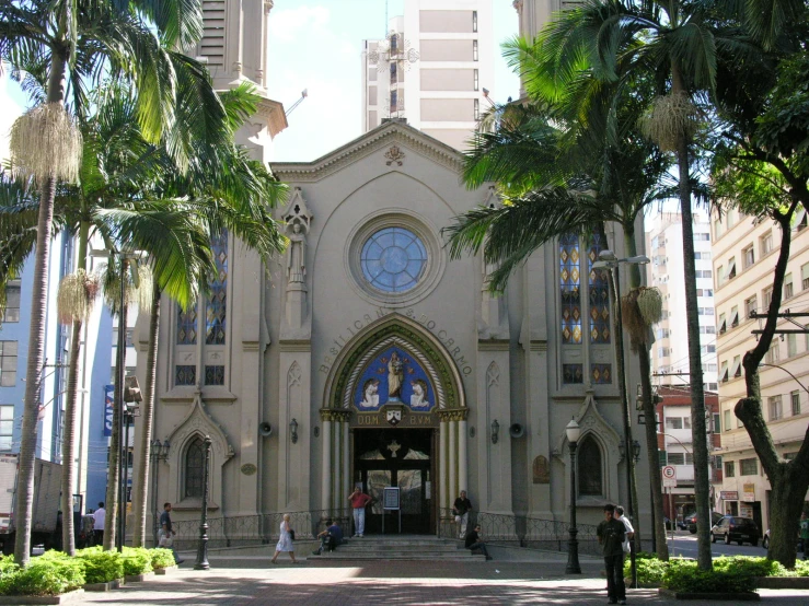 a church with people and palm trees in front of it