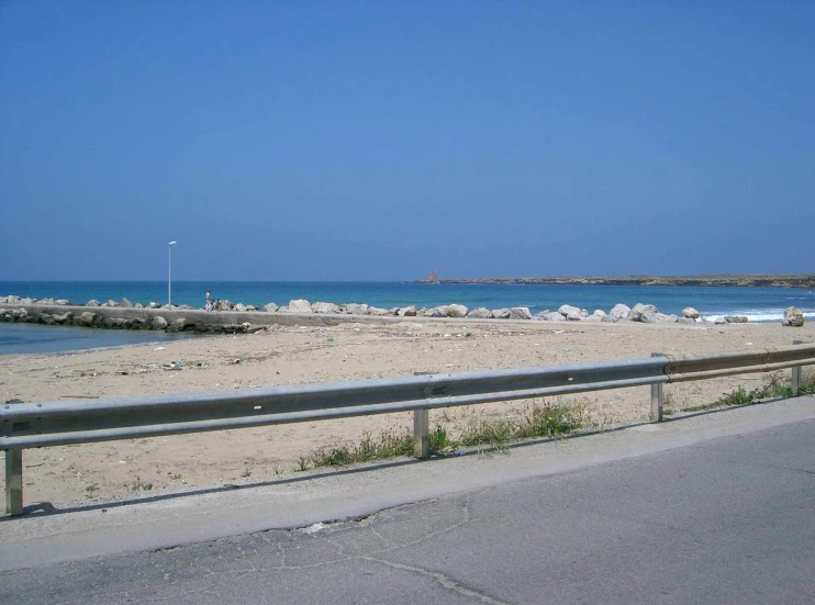 an empty beach with several large rocks next to it