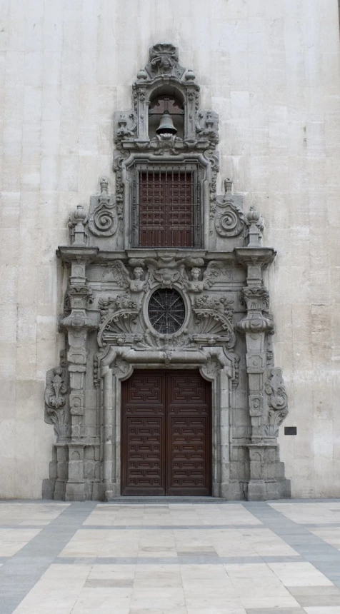 an ornate doorway and door with a checkerboard floor