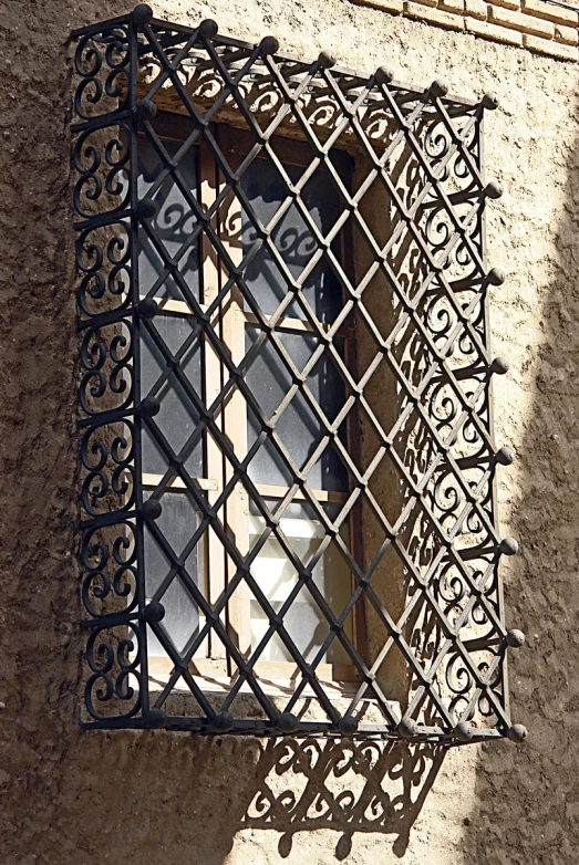 a window with intricate ironwork on it in front of a building