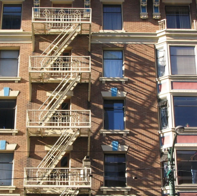 an apartment building with metal staircases near many windows