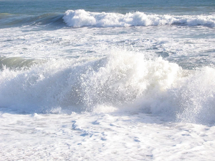 large waves in the water and someone standing on a surfboard