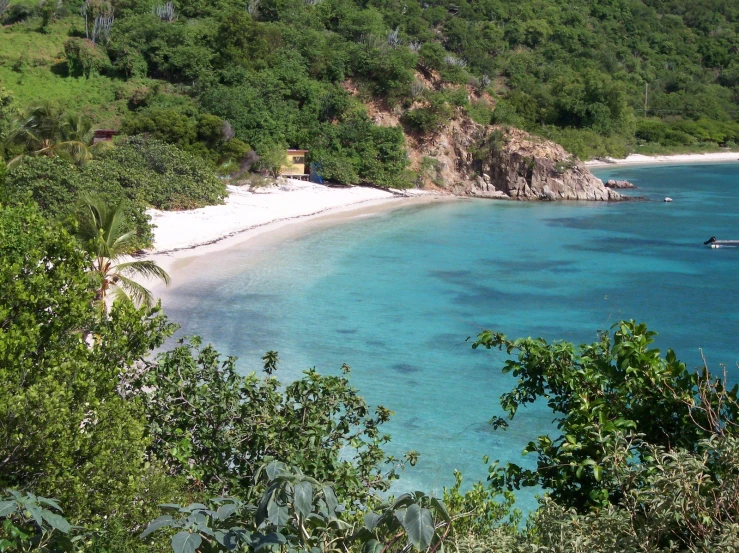 a beach sitting on the side of a hill near some water