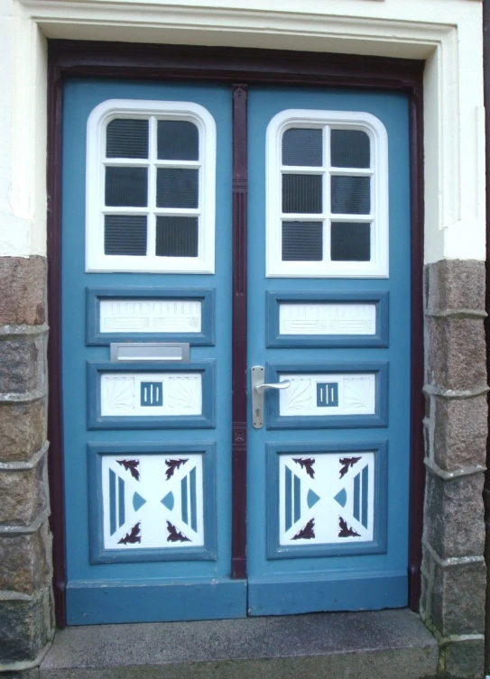 a blue door with white window frames on the front of a house