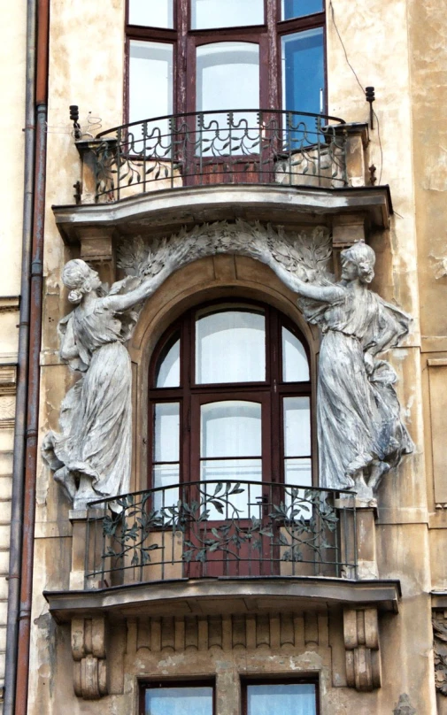 a balcony with two statue standing on top