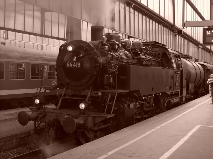 a steam engine train pulling into a station