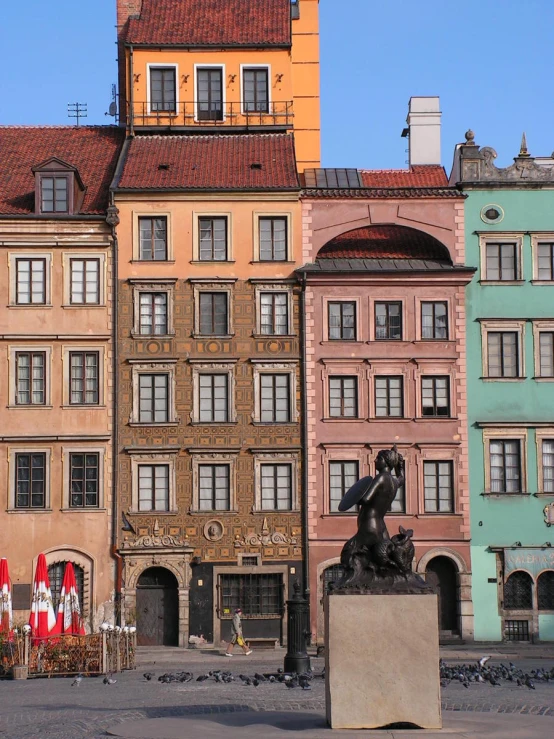 buildings with a stone statue in front of one of them