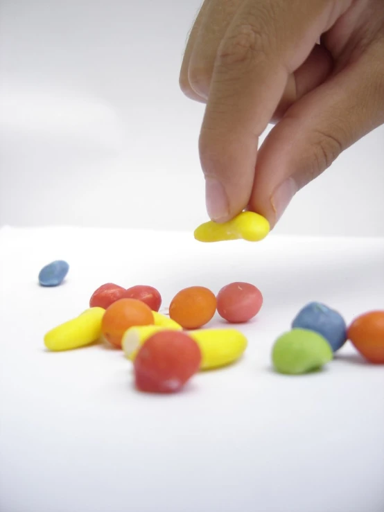 a person is reaching into a pile of candy beans