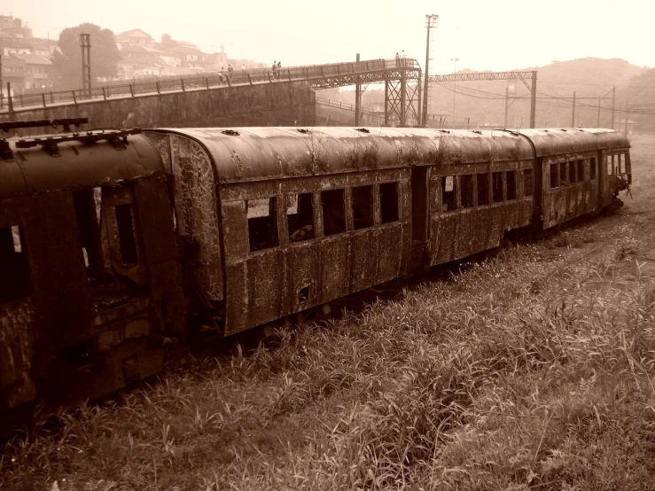 old looking train in grassy field with power lines above