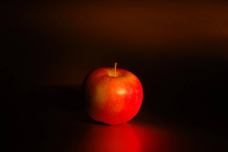 an apple sits on the table with the light coming in