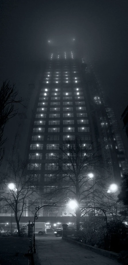 a building at night in the fog with lights on it