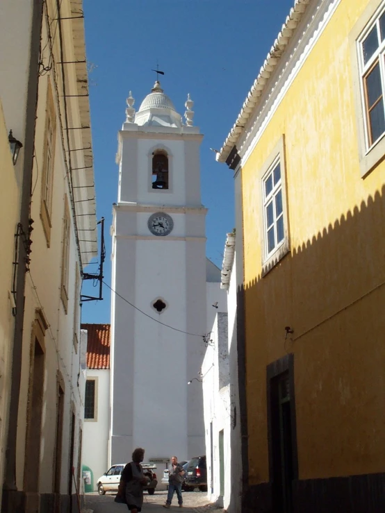 a tall white clock tower towering over a street