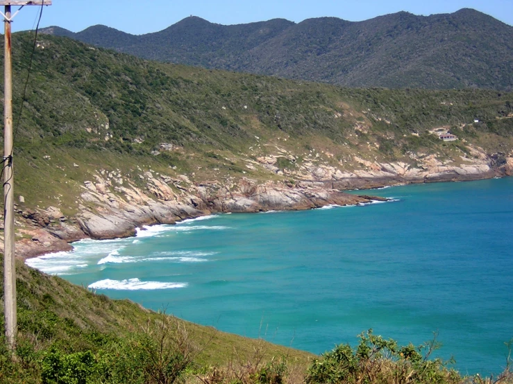 blue water and a beach with a telephone tower