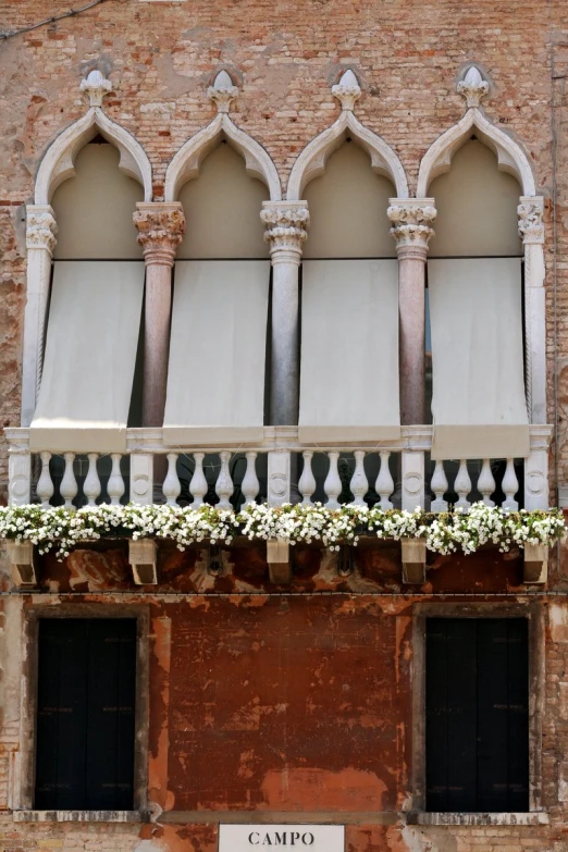 balcony on the side of an old building with flowers