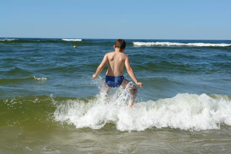 a young man running out to the ocean