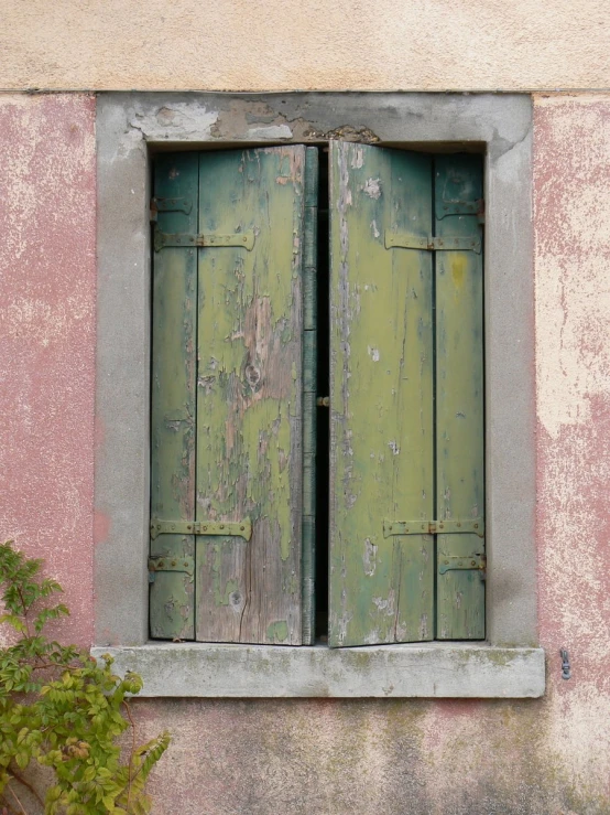 a wooden window sitting inside of a stone wall