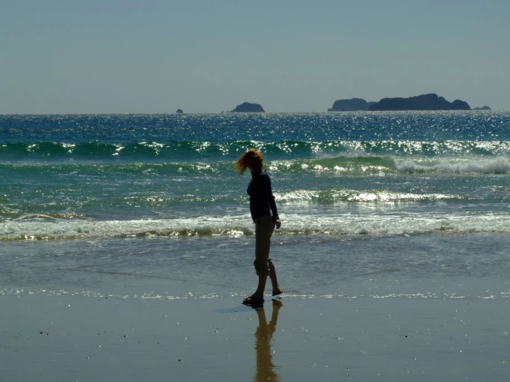 a woman on a beach is standing in the sand