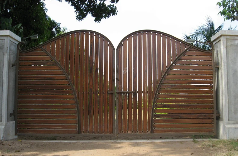 an open wooden gate in front of a park