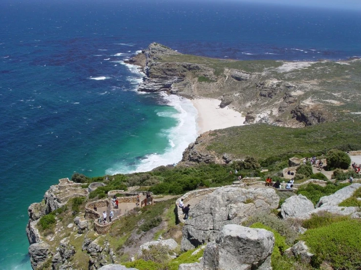 some people hiking in the mountains along the beach