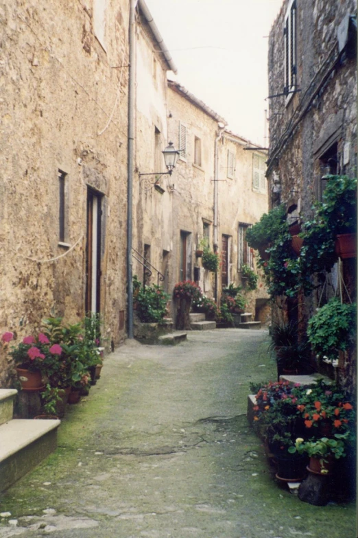 two people walking down a street lined with buildings