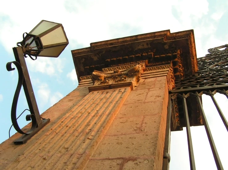 the corner of an old building with the street light beside it