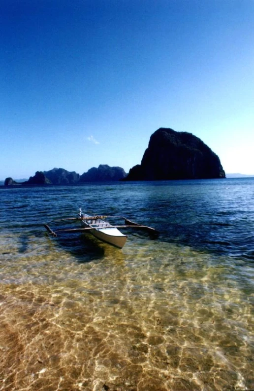 a boat sitting on top of an island next to the ocean