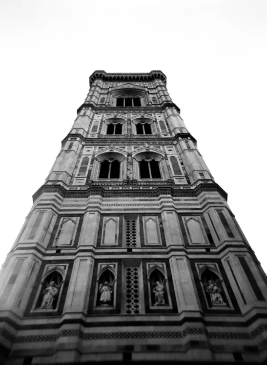 black and white pograph of the top of a building with sculptures on it