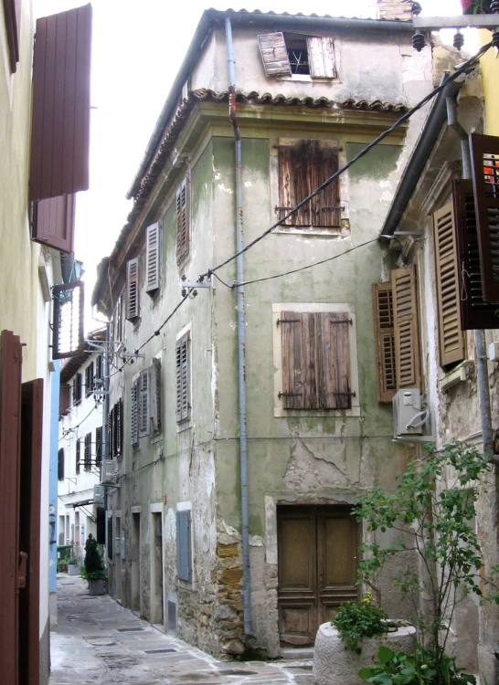 a street with old buildings and windows with wooden shutters