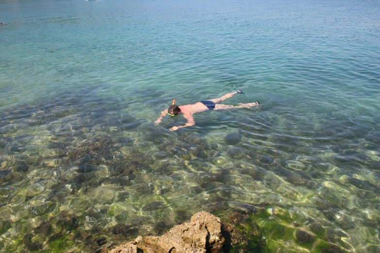 a man is floating in the water of a clear blue ocean