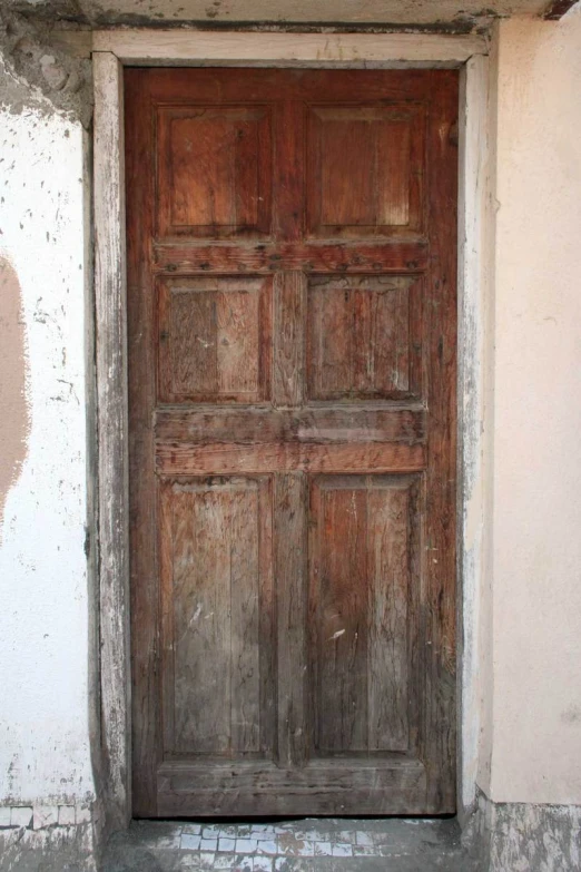 the front door is made of wood and has brick