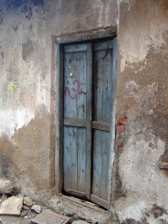 an open doorway with graffiti next to a dirty building