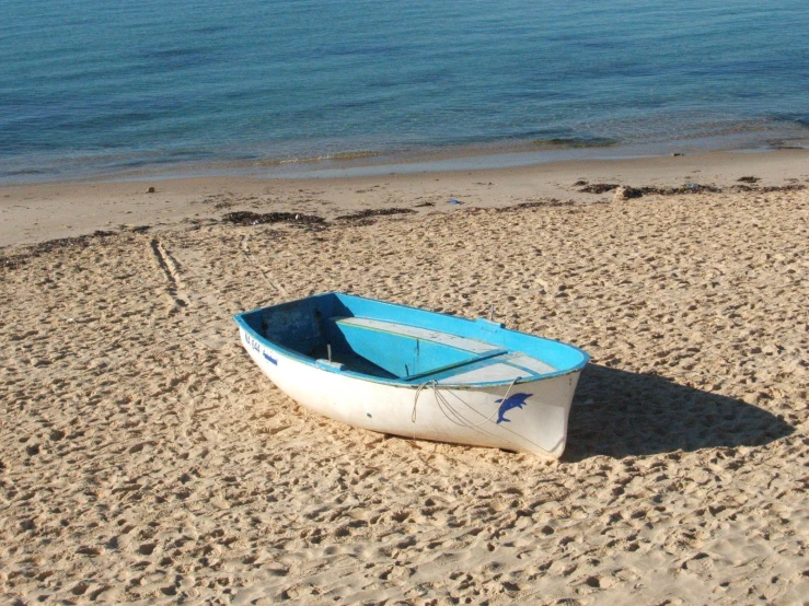 there is a boat on the beach in the sand